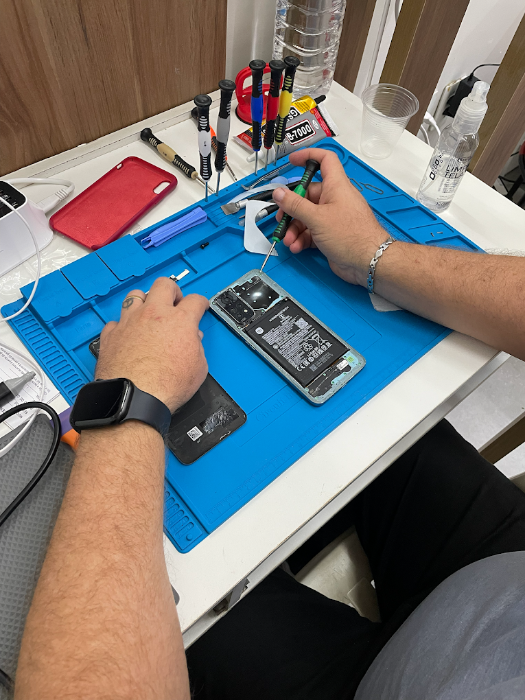 Técnico da iaCell abrindo um celular na bancada de reparo